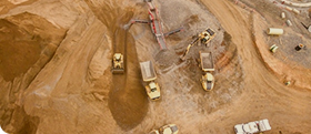 Aerial view of open-pit mine with excavators and dump trucks