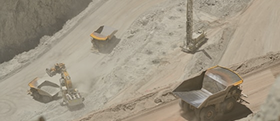 High-angle view of dusty mining site with dump trucks